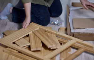 Silla de madera modular desarmada en piezas planas junto a un router CNC EZ4CUT en un taller de carpintería.